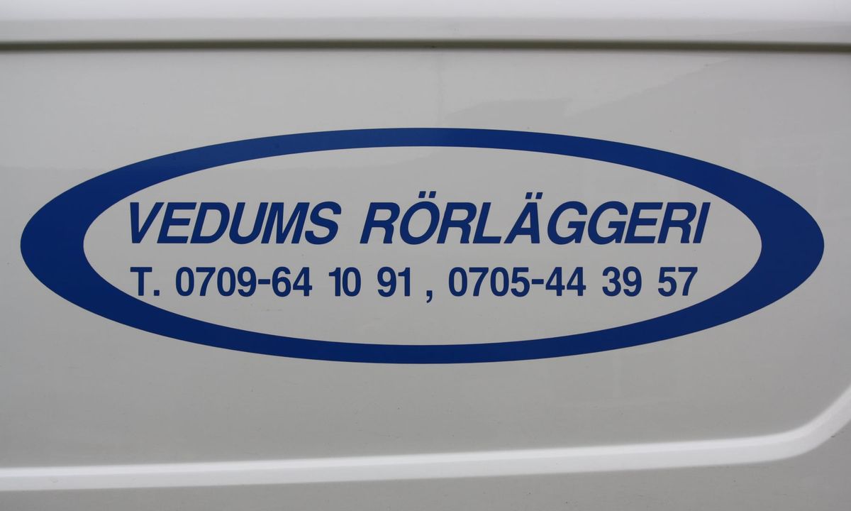Logotypen Vedums Rörläggeri med telefonnummer på sidan av en av firmans servicebilar